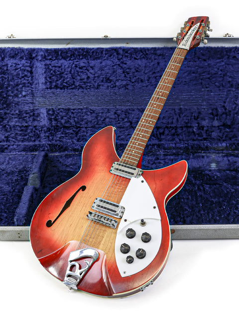 A vintage Rickenbacker 12-string guitar in a protective case, topped with an additional case for extra safety.