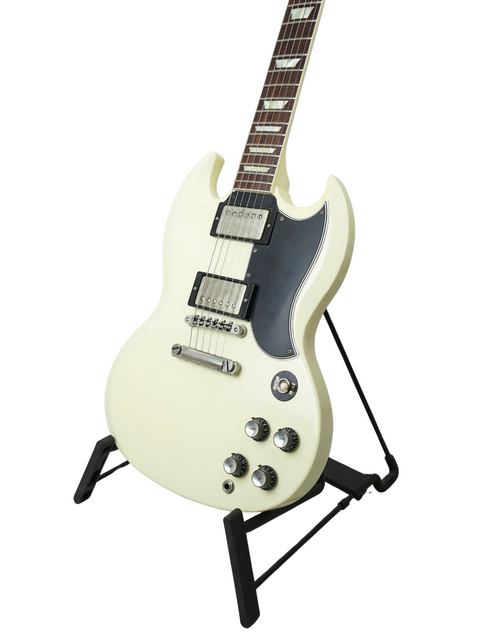 A white Gibson Custom Shop Les Paul SG Standard electric guitar displayed on a stand, showcasing its sleek design.