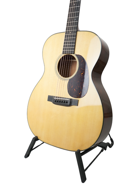 Acoustic guitar, Martin 000-18, proudly displayed on a stand, showcasing its beautiful finish and craftsmanship.