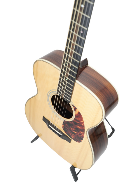 Acoustic guitar on a stand isolated on white background.