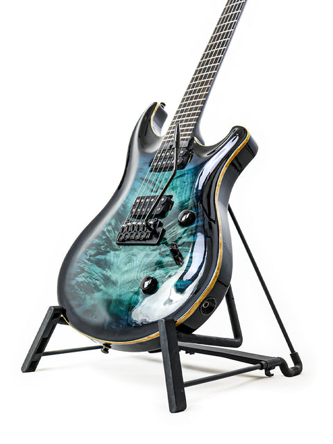 An Orthius Deluxe DC guitar in blue and green resting on a stand, highlighting its craftsmanship from Australia, 2018.