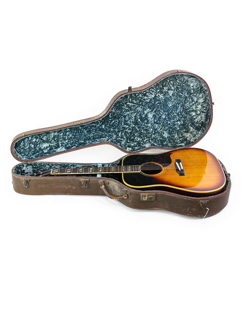 An open guitar case reveals a vintage 1964 Gibson Southern Jumbo, highlighting its elegant features and rich history.