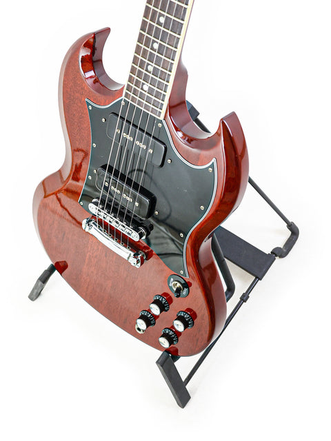 Beautifully crafted Gibson SG Classic guitar resting on a black base stand, a must-have for serious musicians and collectors alike.