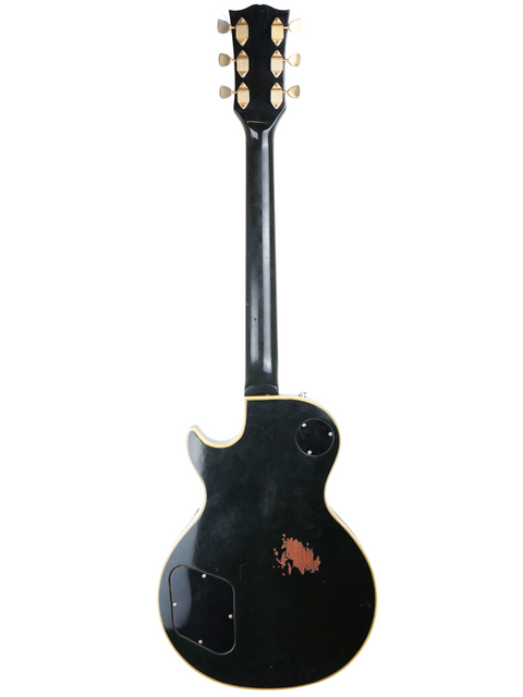 Black 1973 Gibson Les Paul Custom Black Beauty guitar with a distinctive white pickguard, exemplifying vintage style.