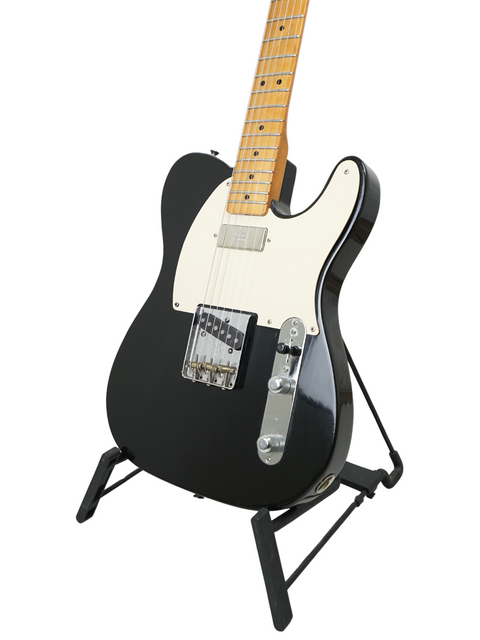 Black and white electric guitar on a stand against a white background.
