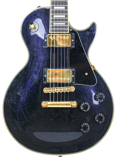 Black electric guitar with a gold pickguard, a Gibson Custom Shop Les Paul Custom from the USA, 1991 model.