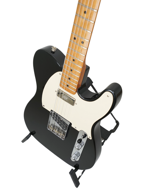 Black electric guitar with a white pickguard on a white background.