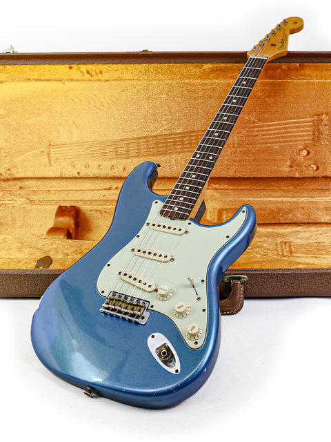 Blue Fender Custom Shop '62 Stratocaster Relic guitar nestled in a case, highlighting its classic style and quality.