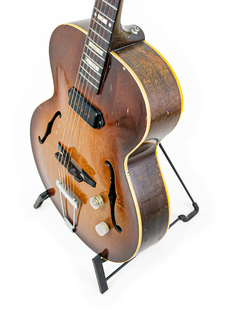 Classic 1948-52 Gibson ES-125 guitar elegantly positioned on a stand with a minimalist white background.