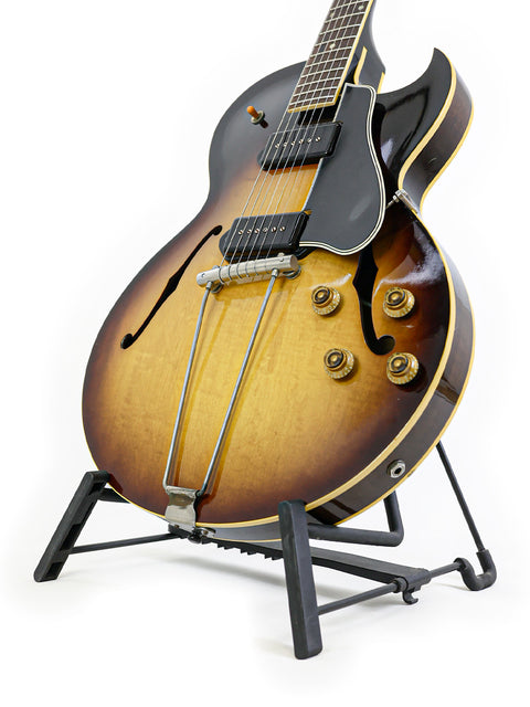 Classic 1959 Gibson ES-225TD guitar on a stand, highlighted by a simple white background for a timeless look.