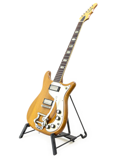 Classic 1964 Epiphone Crestwood Custom guitar resting on a stand, featuring a simple white background.