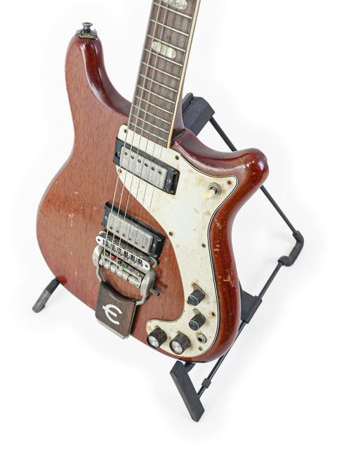 Classic 1966 Epiphone Crestwood Custom guitar resting on a stand, highlighted by a white background.