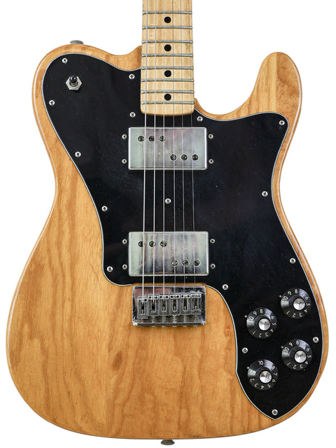 Classic 1973 Fender Telecaster Deluxe guitar with a wooden body and black pickups, embodying timeless musical style.