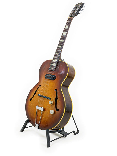 Classic Vintage Gibson ES-125 guitar resting on a stand, highlighted by a stark white background.