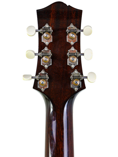Close-up of a guitar headstock with tuning pegs on a white background.
