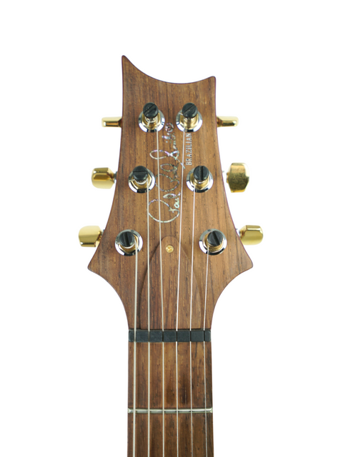 Close-up of the headstock on a PRS Custom 24 acoustic guitar, highlighting the beautiful wooden body craftsmanship.