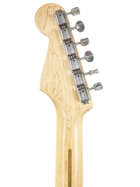 Close-up shot of a 1958 USA Fender Stratocaster guitar head, emphasizing the beautiful wooden body and craftsmanship.