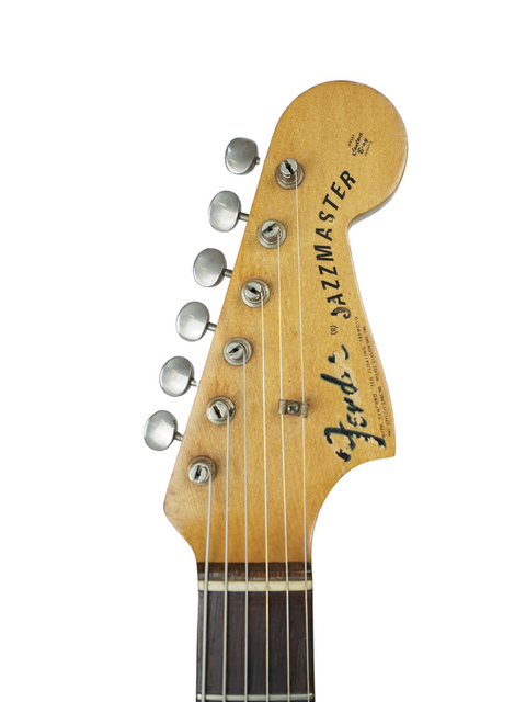 Close-up shot of a 1962 Fender Jazzmaster headstock, featuring its unique shape and vintage finish.