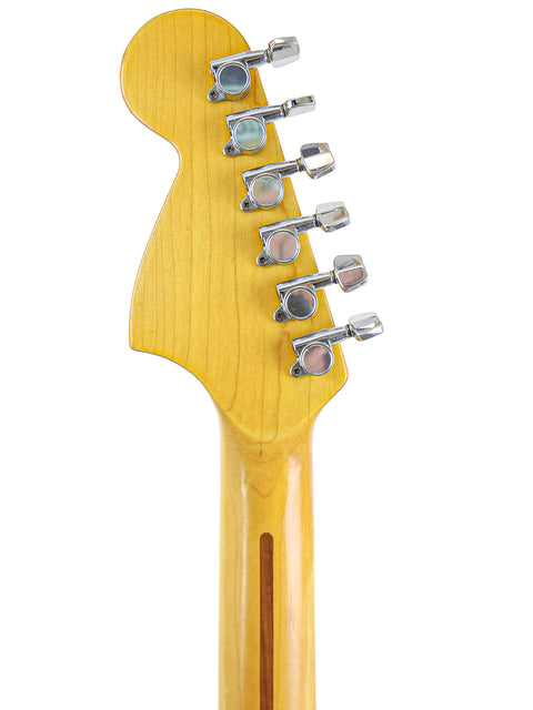 Close-up shot of a vintage Fender Stratocaster guitar head from 1974, featuring a beautifully crafted wooden body.