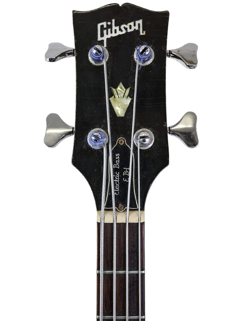 Close-up view of a vintage 1969 Gibson EB-1 bass guitar, focusing on the intricate headstock and rich wood finish.