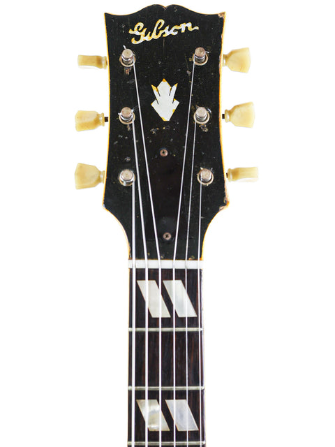 Detailed view of a 1946 Gibson ES-300 guitar, highlighting the elegant black headstock and vintage craftsmanship.