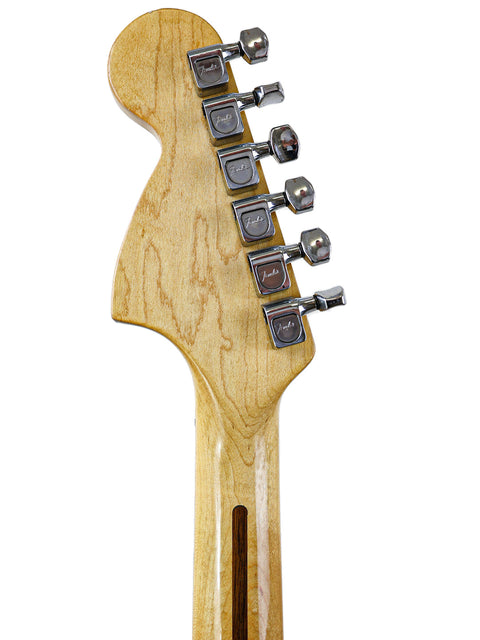 Detailed view of a 1973 Fender Telecaster Deluxe guitar head, highlighting the rich wood grain and vintage craftsmanship.