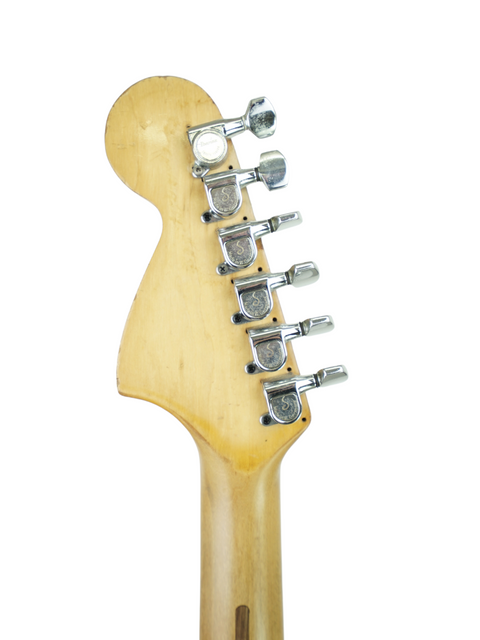 Detailed view of a 1979 Fender Stratocaster guitar head, highlighting its vintage charm on a bright white backdrop.