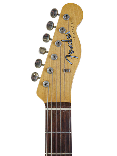 Detailed view of a Fender '59 Custom Telecaster guitar on a white backdrop, showcasing its craftsmanship and design.