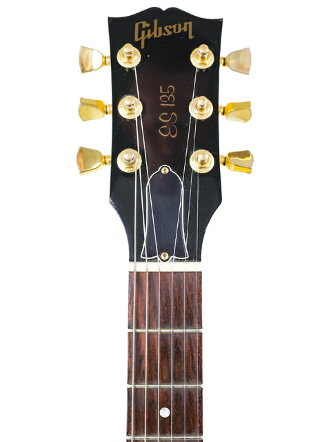 Detailed view of a guitar headstock with "Fender" branding, highlighting the Gibson ES-135 made in the USA, 2002.