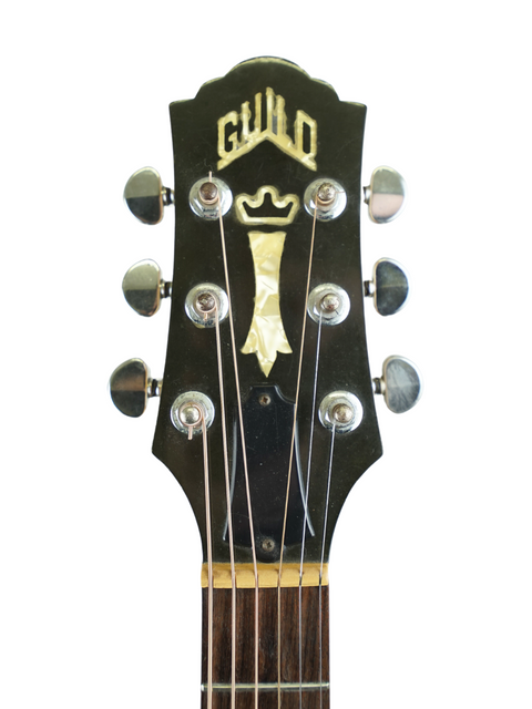 Detailed view of a guitar headstock with "guilo" engraved, highlighting the classic Guild D030A07 Dreadnought from 1987.