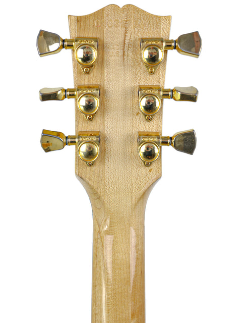 Detailed view of the headstock of a 2002 Gibson ES-135 acoustic guitar, highlighting its unique features and quality.