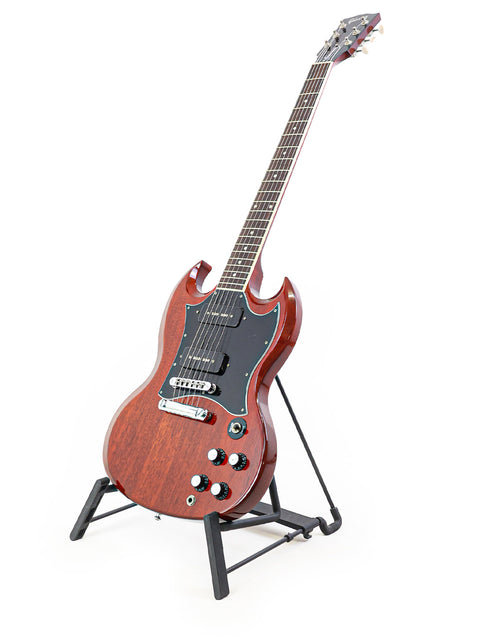 Elegant Gibson SG Classic guitar resting on a stand, set against a white background, ideal for musicians and collectors alike.