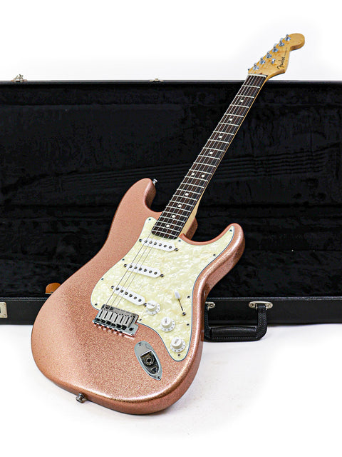Fender Custom Shop American Classic Stratocaster in pink, securely placed in a case on a white background.