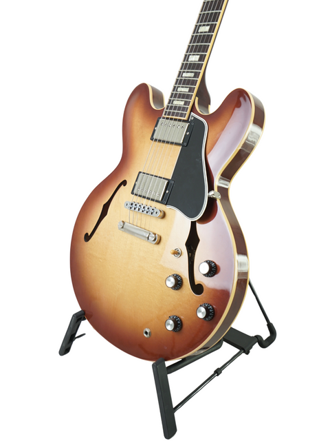 Gibson Custom ES-335 Iced Tea guitar displayed on a stand, set against a bright white background for a striking visual.