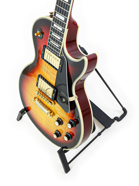 Gibson Custom Shop '68 Reissue Les Paul Custom guitar with a sunburst finish, elegantly positioned on a stand.