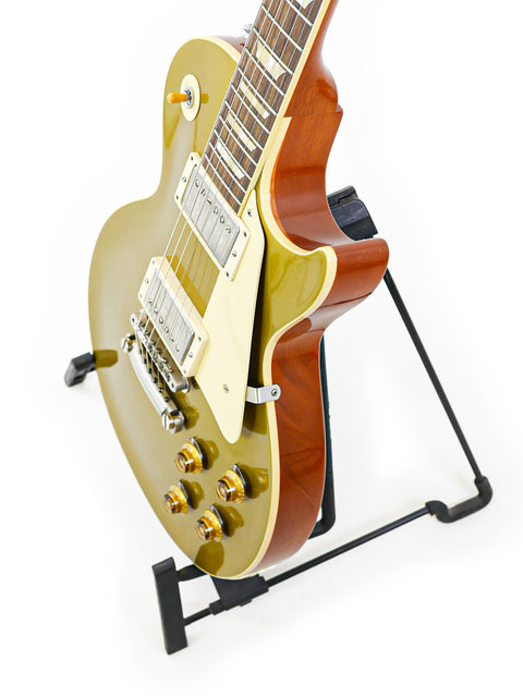 Gibson Custom Shop LPR-7 1957 Les Paul Goldtop Reissue guitar elegantly positioned on a stand with a clean white backdrop.