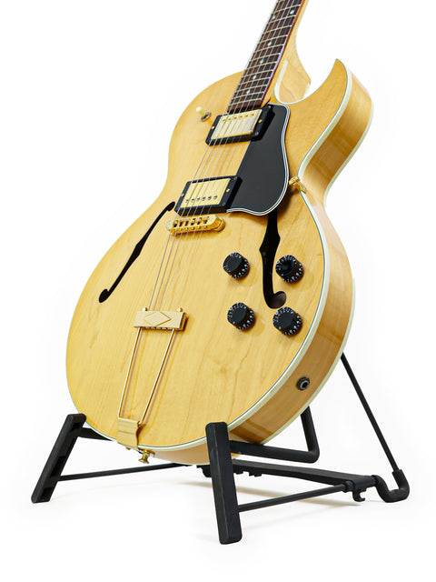 Gibson ES-135 guitar, USA 2002 model, elegantly positioned on a stand with a white backdrop.