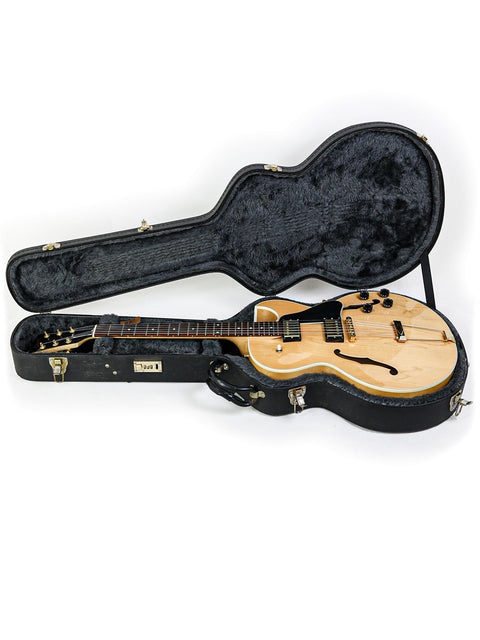 Gibson ES-135 guitar from 2002, securely placed in a case on a pristine white background.