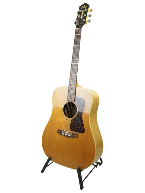 Guild D030A07 Dreadnought guitar on a stand, showcasing its classic design against a clean white background.