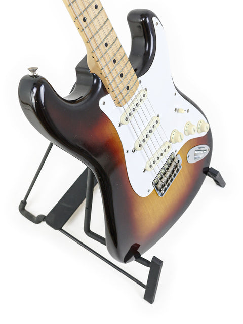 Iconic 1958 Fender Stratocaster, boasting a black body and white pickguard, representing vintage guitar craftsmanship