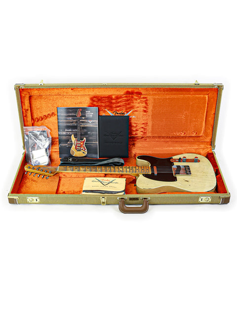 Inside a guitar case, a Fender Custom Shop 70th Anniversary Nocaster rests, highlighting its unique features and artistry.