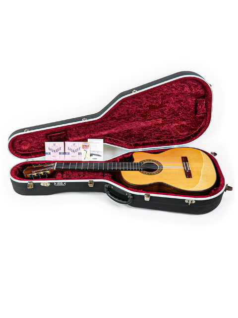 Inside a vibrant red case lies a Robin Moyes Custom guitar, showcasing Australian craftsmanship from 2002.