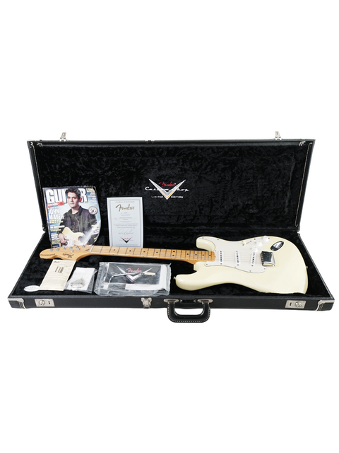 Inside a white guitar case, a Fender Custom Shop Stratocaster and accessories are displayed, highlighting its exclusivity.