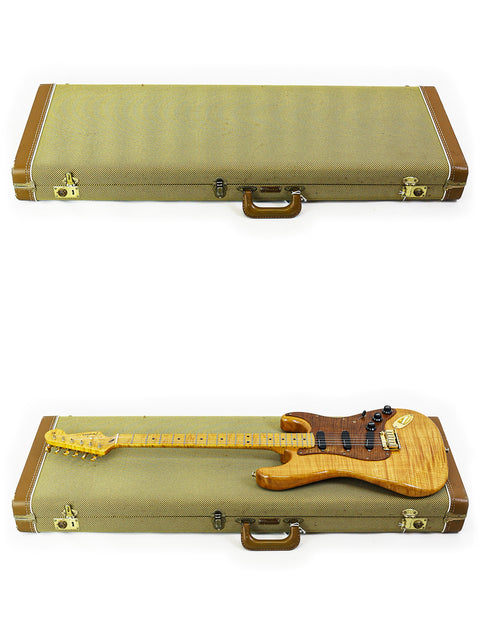 On a white background, a case holds two guitars, prominently featuring a 1992 Fender Custom Shop 'Clapton' Stratocaster.