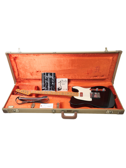 Open guitar case with a black electric guitar, cable, and some papers.