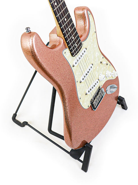 Pink Fender Stratocaster guitar elegantly positioned on a black base stand, a classic model from the Custom Shop, 1994.