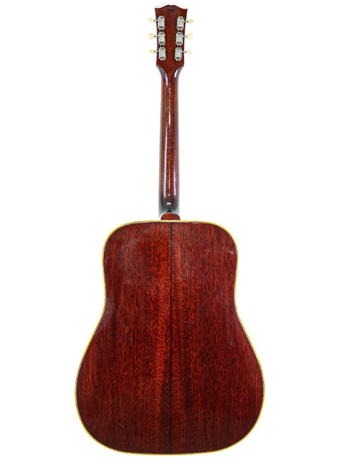 Rear perspective of a vintage Gibson Southern Jumbo acoustic guitar from 1964, highlighting its wooden back.