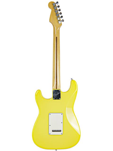 Rear view of a yellow electric guitar on a white background.