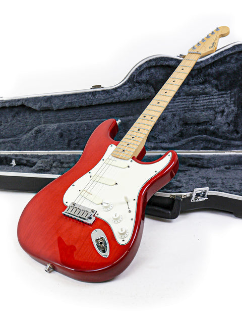 Red electric guitar, Fender Strat Plus Deluxe 1993, with a case, set on a clean white background.