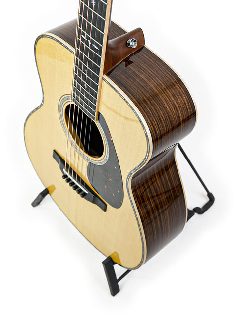 Small Yamaha LS36 ARE acoustic guitar on a stand, featuring a stylish design, crafted in Japan in 2020.
